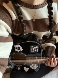 a woman holding a black and white guitar