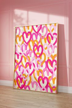 an abstract painting with pink, yellow and orange hearts on it in front of a pink wall