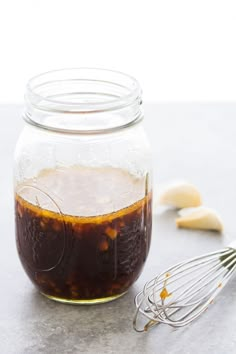 a glass jar filled with liquid and whisks