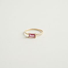 From our birthstone collection this exquisite natural ruby features a rare and delicate pink hue, radiating elegance and sophistication.  Celebrate the vibrancy of July with this stunning emerald-cut ruby crafted in 14K gold. Materials:  14K Solid gold .35 ct. Natural Ruby .79 Gold grams    Care Instructions: Storage: Store your jewelry in a cool, dry place, preferably in a fabric-lined jewelry box or pouch. Keep pieces separate to avoid scratching. Avoid Chemicals: Keep your jewelry away from harsh chemicals, such as bleach, chlorine, and household cleaners. These can damage metals and dull gemstones. Regular Cleaning: Clean your jewelry regularly with appropriate methods to maintain its brilliance and prevent buildup of oils and dirt. Timeless Emerald-cut Ruby Ring, Rose Gold Baguette Cut Gemstone Jewelry, Elegant Emerald Cut Tourmaline Jewelry, Fine Jewelry In Yellow Gold With Pink Sapphire, Yellow Gold Pink Sapphire Fine Jewelry, Elegant Birthstone Baguette-cut Jewelry, Elegant Birthstone Jewelry With Baguette Cut, Elegant Birthstone Jewelry In Baguette Cut, Pink Sapphire Jewelry With Gemstone Accents For Wedding