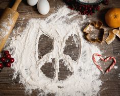 flour, cookie cutters, candy canes and other ingredients laid out on a table