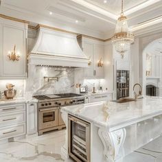 a large kitchen with marble counter tops and white cabinets, along with an island in the middle