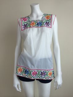 cross stitch needlepoint hand-embroidered tunic top w/ crocheted trim 'Creaciones Fany' made in Mexico dacron & cotton blend -machine washable- no tag size, fits modern small 38 inch bust, 38 inch waist 28 inch length 4 inch slits on either side unlined great condition, normal light wear Spring Cotton Embroidered Top With Machine Embroidery, Folk Style Spring Tops With Machine Embroidery, Spring Folk Style Tops With Machine Embroidery, Spring Folk Tops With Machine Embroidery, Bohemian Cotton Tops With Machine Embroidery, Geometric Embroidery Crew Neck Cotton Tops, Fitted Cotton Top With Geometric Embroidery, Fitted Cotton Tops With Geometric Embroidery, Bohemian Cotton Blouse With Machine Embroidery