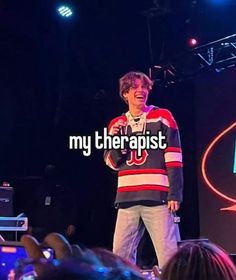 a young man standing on top of a stage in front of a group of people