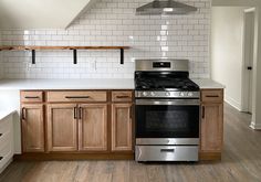 a stove top oven sitting inside of a kitchen next to wooden cabinets and counter tops