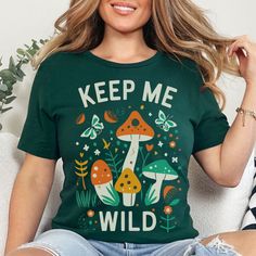 Retro Mushroom Shirt for Women Oversized Tshirt Nature Lover Gift Shirt for Her T Shirt Forest T-Shirt Boho Graphic Tee Women Keep Me Wild Embrace the outdoors with this boho mushroom shirt, a retro graphic tee that's perfect as an oversized nature lover gift for your free spirited friend or family member encouraging them to stay wild!  🍍𝗣𝗥𝗢𝗗𝗨𝗖𝗧 𝗜𝗡𝗙𝗢𝗥𝗠𝗔𝗧𝗜𝗢𝗡: * Exact Measurement Info in Listing Photos * Bella Canvas Unisex Short Sleeve Tee * Runs True to Size * Super Soft * 6 Sizes: S-3XL * Available in Asphalt, Autumn, Black, Forest Green, Maroon, Olive, Team Navy & Team Purple.  * Price is Same for All Sizes & Colors 🍍𝗖𝗔𝗥𝗘 𝗜𝗡𝗦𝗧𝗥𝗨𝗖𝗧𝗜𝗢𝗡𝗦: Wash Inside Out in Cold Water. No Bleach. Don't Dry Clean. Do Not Iron Directly on the Design 🍍𝗛𝗢𝗪 𝗧𝗢 𝗢𝗥𝗗𝗘𝗥 Green Fun T-shirt With Screen Print, Fun Green T-shirt With Screen Print, Trendy Green T-shirt For Fall, Green Printed Crew Neck Top, Casual Green Printed Tops, Green Trendy Top With Graphic Print, Green Short Sleeve Tops For Fall, Cute Green Crew Neck Top, Fun Graphic Print Short Sleeve Tops