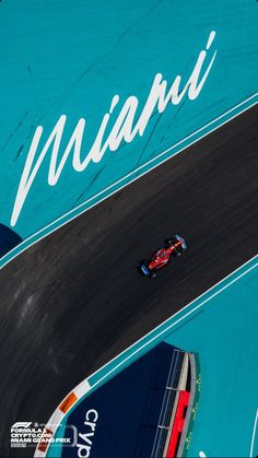 an aerial view of a race car driving on a track with the word miami painted on it