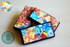 four colorful coasters sitting on top of a wooden table