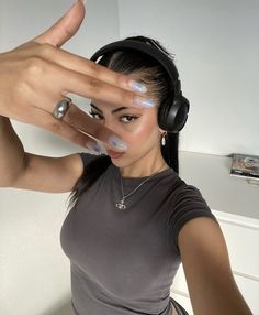 a woman with headphones on holding her hand up