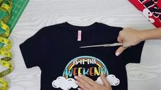 someone using scissors to cut the back of a t - shirt