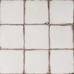 a white tiled wall with square tiles on it