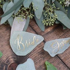 the bride and groom's name stones are sitting on top of some green leaves