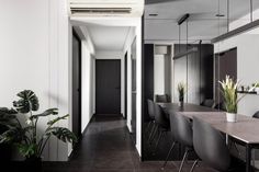 a long table and chairs in a room with mirrors on the wall, plants near by