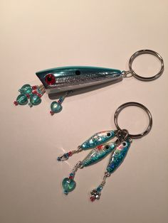 two fish shaped key chains with beads on them