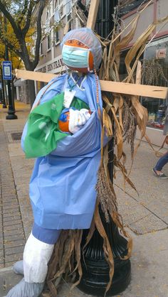 a scarecrow sitting on top of a black pole