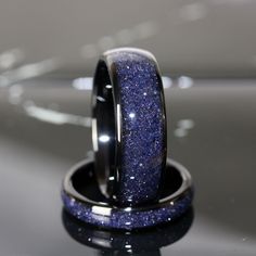 two wedding rings with blue glitter on them