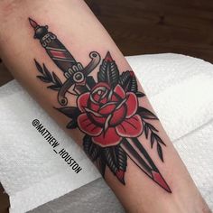 a rose and dagger tattoo on the arm with an arrow in the center is shown