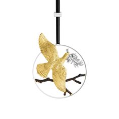 a glass ornament with a gold bird on a branch in the center and a white background