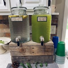 two large glass jars with lids sitting on top of a wooden crate