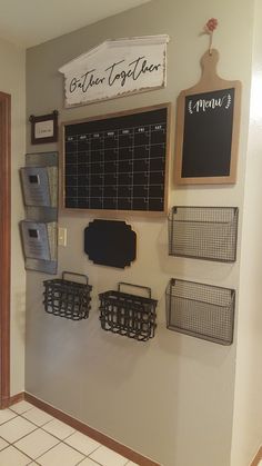 a wall mounted chalk board with baskets on it