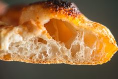 a piece of bread that is being held up to show it's inside and outside