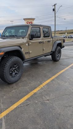 a tan jeep parked in a parking lot