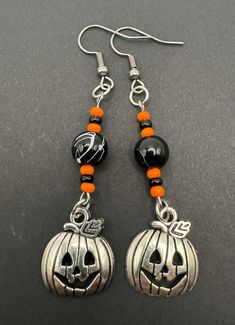 the earrings are decorated with black and orange beads, silver pumpkins and bead accents