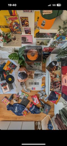 a table topped with lots of assorted items next to a wall covered in pictures