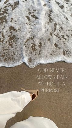 someone is standing on the beach with their feet in the sand and there is a message that says, god never allows pain without a purpose