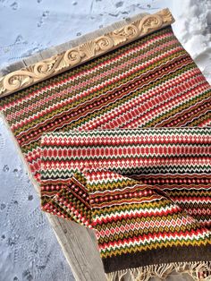 a blanket is laying on top of a wooden bench in the snow with it's edge partially covered