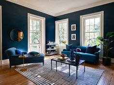 a living room with blue walls and wooden floors, two couches and a coffee table