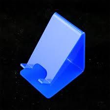 a blue plastic object on a black surface with space for the letter t to be inserted