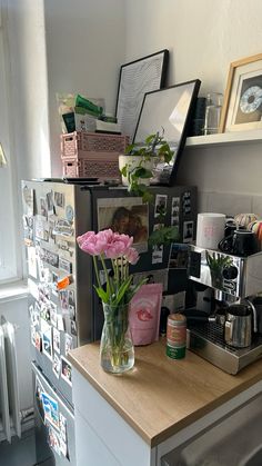 a kitchen counter with flowers and pictures on the wall