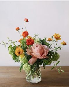 a vase filled with lots of different colored flowers