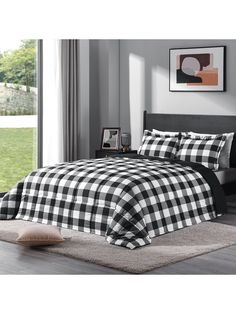 a black and white checkered comforter set on a bed in front of a window