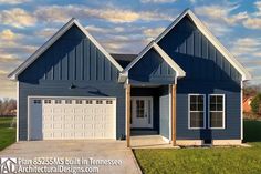 a blue house with two garages on the front and one door in the back