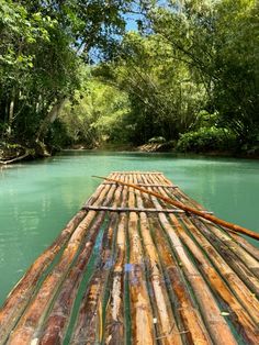 a bamboo raft floating on top of a river surrounded by trees in the jungles