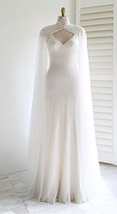 a white wedding dress on display in front of a window