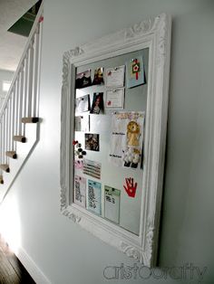 a white framed photo hanging on the wall next to a stair case in a house