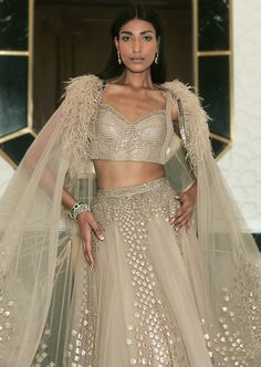 Our Eden lehenga fully embellished with delicate embroideries. Paired up with asymmetric embellished cape. Glamorous Embellished Wedding Sets, Glamorous Floor-length Sets With Intricate Embroidery, Glamorous Festive Sets With Cape Sleeves, Glamorous Designer Lehenga With Intricate Embroidery, Glamorous Dupatta For Reception With Traditional Drape, Glamorous Gown With Saree Shape And Intricate Embroidery, Glamorous Gown With Intricate Embroidery In Saree Style, Glamorous Traditional Drape Dupatta For Reception, Glamorous Gown With Sheer Dupatta For Festive Occasions