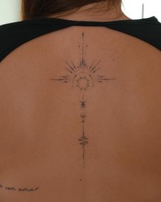 the back of a woman's shoulder with a sun and stars tattoo on it