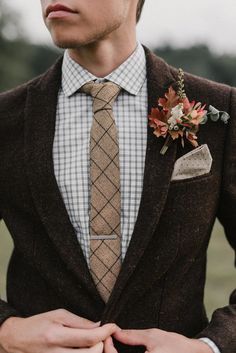 a man wearing a suit and tie with a boutonniere on his lapel