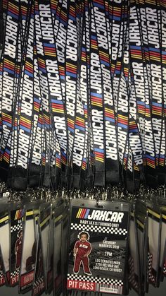 many nascar cards are stacked on top of each other in plastic holders with tags attached to them