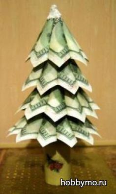 a small christmas tree made out of dollar bills