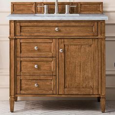 a bathroom vanity with two faucets on the top and one sink below it