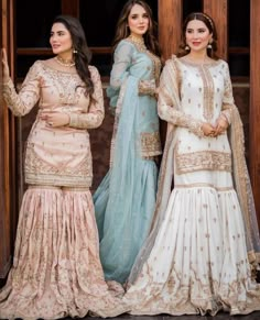 three women in long dresses standing next to each other