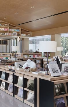 an empty library with many books on shelves and lamps in the corner, along with several tables full of books