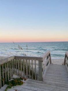 two wooden steps leading to the beach at sunset