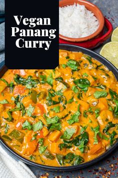 vegan panang curry in a skillet with rice and cilantro on the side