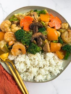 a plate with rice, broccoli, carrots and cauliflower on it